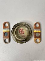 Ashtray centered with two wooden cigar cutters flanking