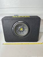 Front view showing full enclosure and driver with measuring tape for scale