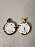 Front view of both pocket watches showing dials