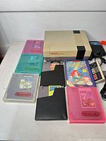 Console with multiple game cartridges and protective cases displayed