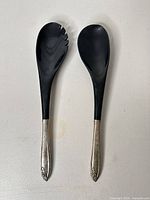 Front view of both salad servers showing black bowls and sterling handles
