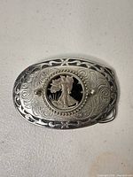 Front view of belt buckle showing overall design and coin centerpiece