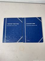 Closed front covers of both Whitman folders