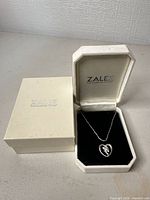 Necklace displayed in open Zales box with outer box beside it