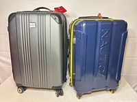 Front view of both suitcases showing colors, brand logos and exterior condition