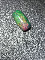 Top view of cabochon showing vivid green and multicolour play-of-colour