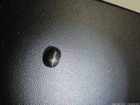 Top view of black oval cabochon showing 4-ray star