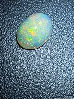 Top view of oval opal showing pinfire play of color