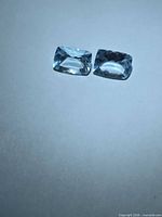 Pair of pale blue cushion-cut aquamarines on white background