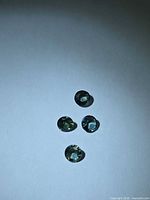 Four round green-blue sapphires on white background