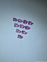 Ten square pink sapphires arranged in inverted triangle