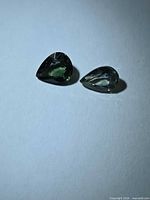 Both pear-cut sapphires face up showing colour difference