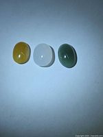 Front view of three jade cabochons showing colours and oval shapes