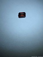 Top view of rectangular red spinel on neutral background