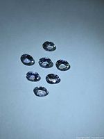 Seven oval-cut Tanzanite gemstones on white background