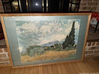 Front view of framed Vincent van Gogh Wheatfield print leaning against fireplace