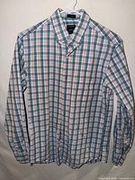 Full frontal view of the plaid shirt on hanger