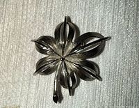 Front view of silver-tone five-petal flower brooch