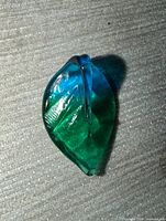 front view of translucent blue-green glass leaf pendant