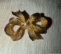 Front view showing gold-tone bow shape and rhinestones