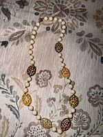 Full view of necklace laid flat showing bead pattern and clasp