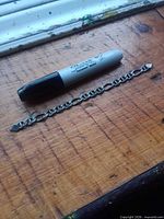 Full bracelet next to large Sharpie for scale