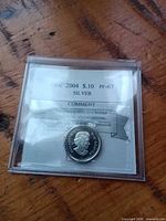 Front of holder showing label CAN 2004 S.10 PF-67 SILVER and obverse of dime