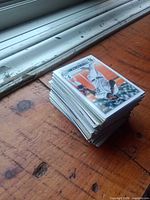 Tall stack of baseball cards on wooden surface