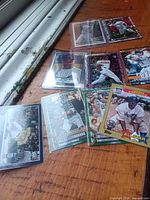 Group shot of approximately eleven baseball trading cards on wooden surface