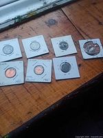 All seven coins in flips on wooden surface