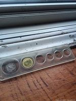 Six-slot plastic coin holder with two Canadian coins