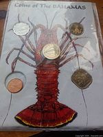 Front view of display sleeve showing five loose Bahamas coins around lobster illustration