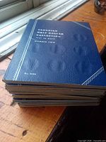 Stack of blue Whitman folder covers, top showing Canadian Half Dollar Collection 1941-Date Number Two No.9054