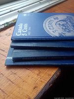 Stack of coin folders showing Canada 5 Cents 1922-Date cover and spine of additional Canadian Nickels folder