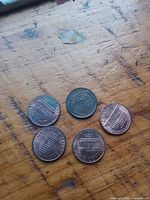 rear view of five pennies showing wheat and memorial reverses