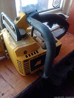 Left side of chainsaw housing, handle and vents visible