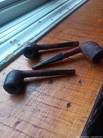 All three pipes on wooden surface showing overall appearance