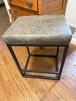 Assembled grey faux leather stool showing seat and metal frame