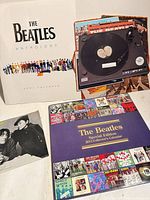 Group shot showing both calendars, Lennon 45 sleeve and trivia spinner board
