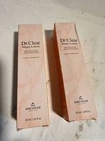 Two boxed Dr. Clear Magic Lotion products, front panels visible