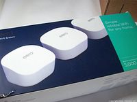 Front of box showing three white eero units and 5,000 sq ft coverage claim