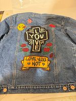 Back of denim jacket showing embroidered and appliqué graphics