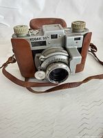 Front view of Kodak 35 camera in leather case showing lens, body and strap