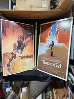 Both mounted posters side by side with tape measure for scale