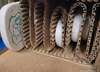 corrugated inner packaging showing white ceramic wind chime element with green turtle design