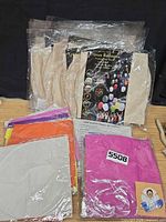 Stacks of sealed packages of assorted color folded paper lanterns with black retail packaging in background