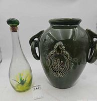 Overall view of glass decanter and green ceramic vase together