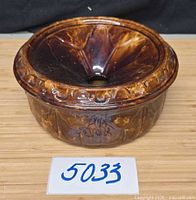Top and front view of brown glazed pottery spittoon