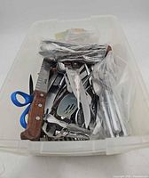 top view of bin showing mixed flatware and utensils