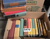 U-Haul box containing tan Will Durant volumes, Great Religions series, other books